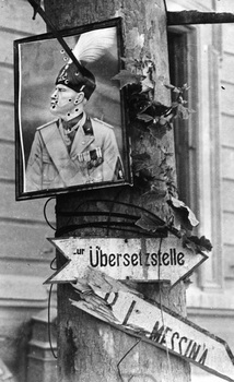 A bullet-holed portrait of Italian dictator Benito Mussolini fixed to a tree.jpg