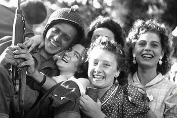 A group of French teenage girls hugs a soldier during the liberation of Paris.jpg