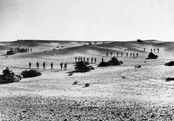Australian troops marching behind the tanks during a rehearsal of the offensive in the sands of North Africa.jpg