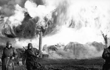 Deutsche Soldaten vor einem brennenden Dorf 1941.jpg
