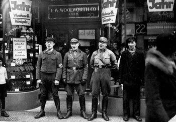 Four Nazi troops sing in front of the Berlin branch of the Woolworth Co. store during the movement to boycott Jewish presence in Germany, in March, 1933.jpg