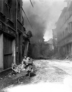 German woman carrying a few possessions runs from burning building.jpg
