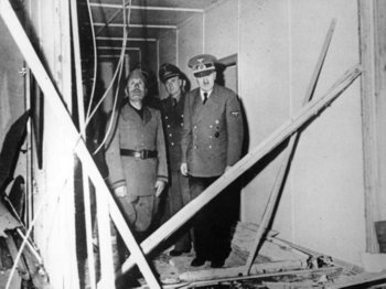 Hitler mit Mussolini und Chefdolmetscher Paul-Otto Schmidt in der zerstörten Lagebaracke.jpg