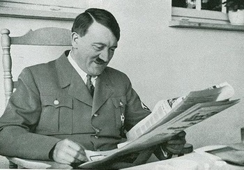 Hitler smiles while reading newspaper.jpg