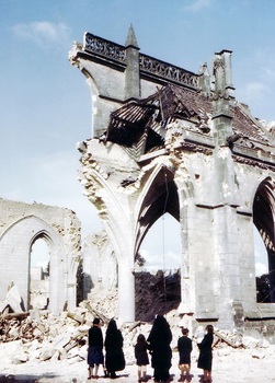 Nuns and some children look on at the ruins of an almost totally destroyed church.jpg