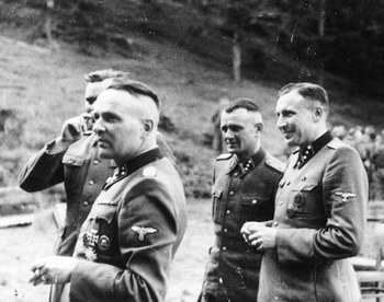Rudolf Höss (left) and other SS officers gather for drinks in a hunting lodge.jpg