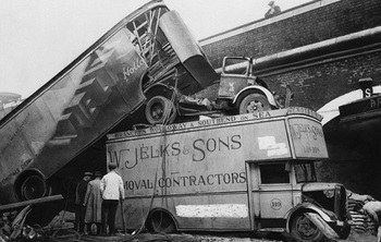 The force of a bomb blast in London piled these furniture vans atop one another in a street after a raid on December 5, 1940..jpg